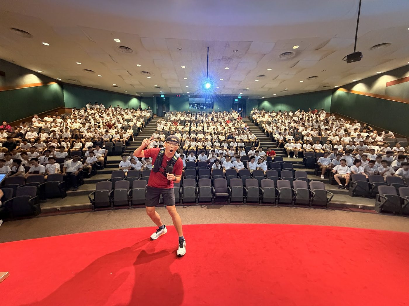 Runner Kao speaking at Singapore school auditorium to students